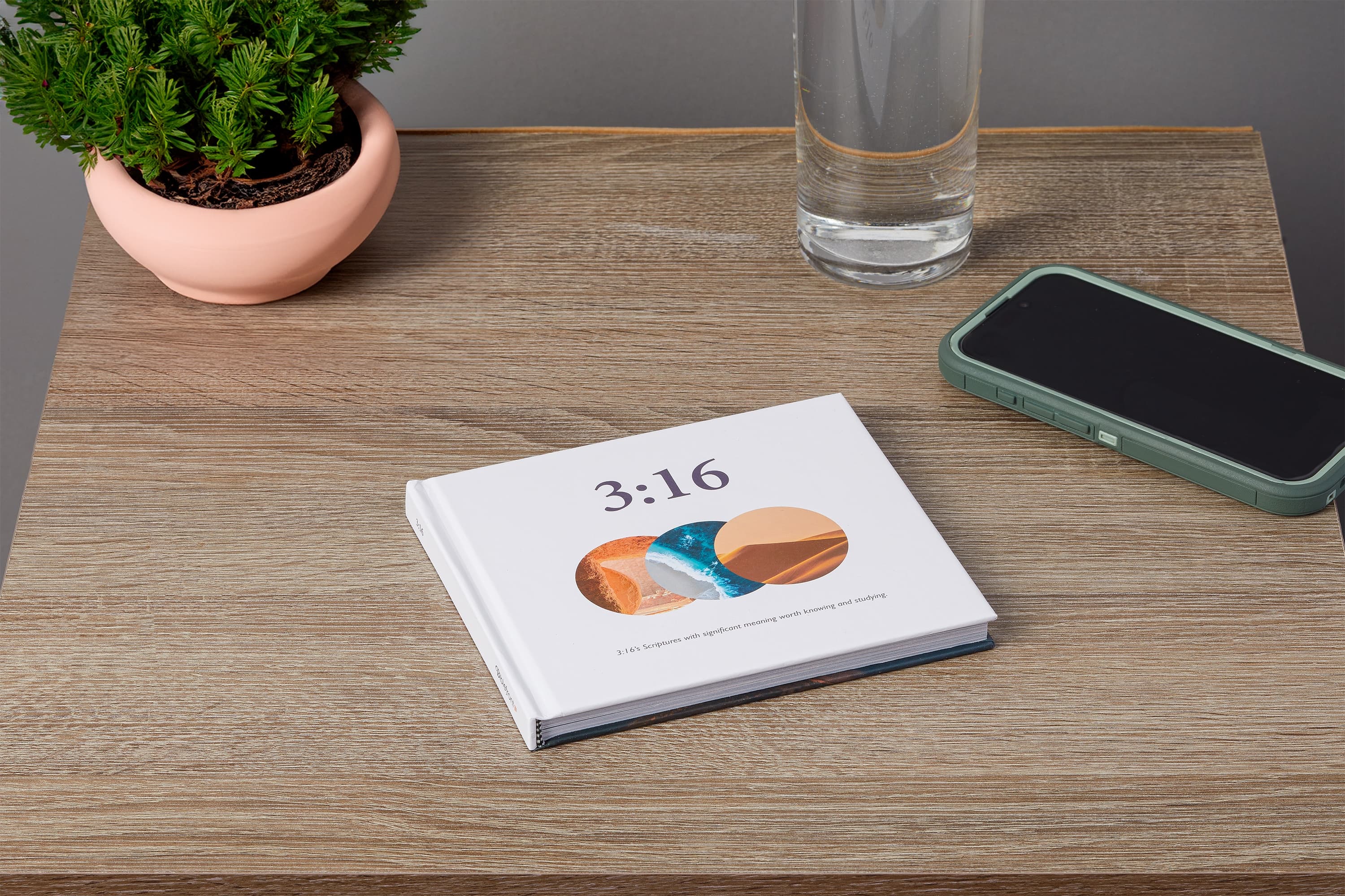 3:16 displayed beside a lamp and journal